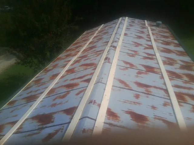 Rusted metal roof panels with new wood purlins before replacement — Storm Damage Roof Repair in Corolla by Roofing Brothers